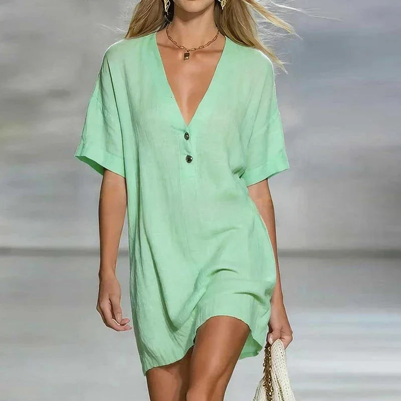 Green - Woman wearing a textured linen short sleeve mini dress with a relaxed fit and partial button front detail