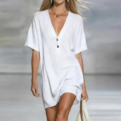 White - Woman wearing a textured linen short sleeve mini dress with a relaxed fit and partial button front detail