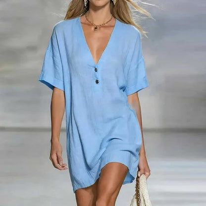 Blue - Woman wearing a textured linen short sleeve mini dress with a relaxed fit and partial button front detail