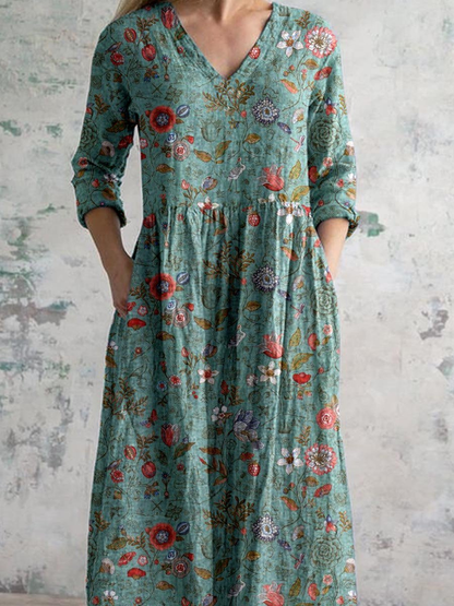 3XL - Woman wearing a long, textured floral maxi dress with 3/4 sleeves and hands resting in side pockets