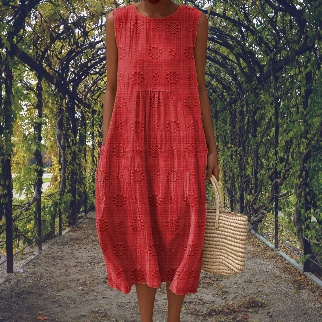 Red - Woman wearing a sleeveless, A-line midi sundress featuring an all-over 3D floral applique pattern and side seam pockets, standing on a gravel path.