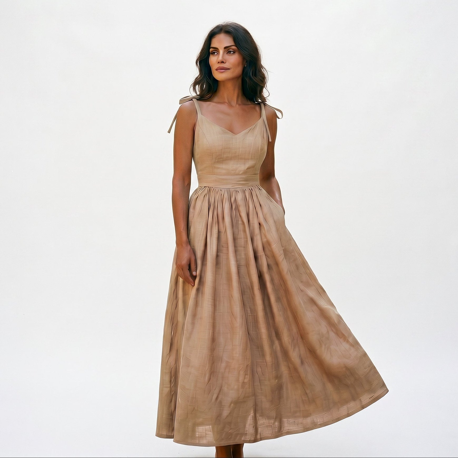 Khaki - Model wearing a solid woven maxi dress featuring tie-shoulder straps, a fitted waist, and a full sweeping skirt against a white studio background.