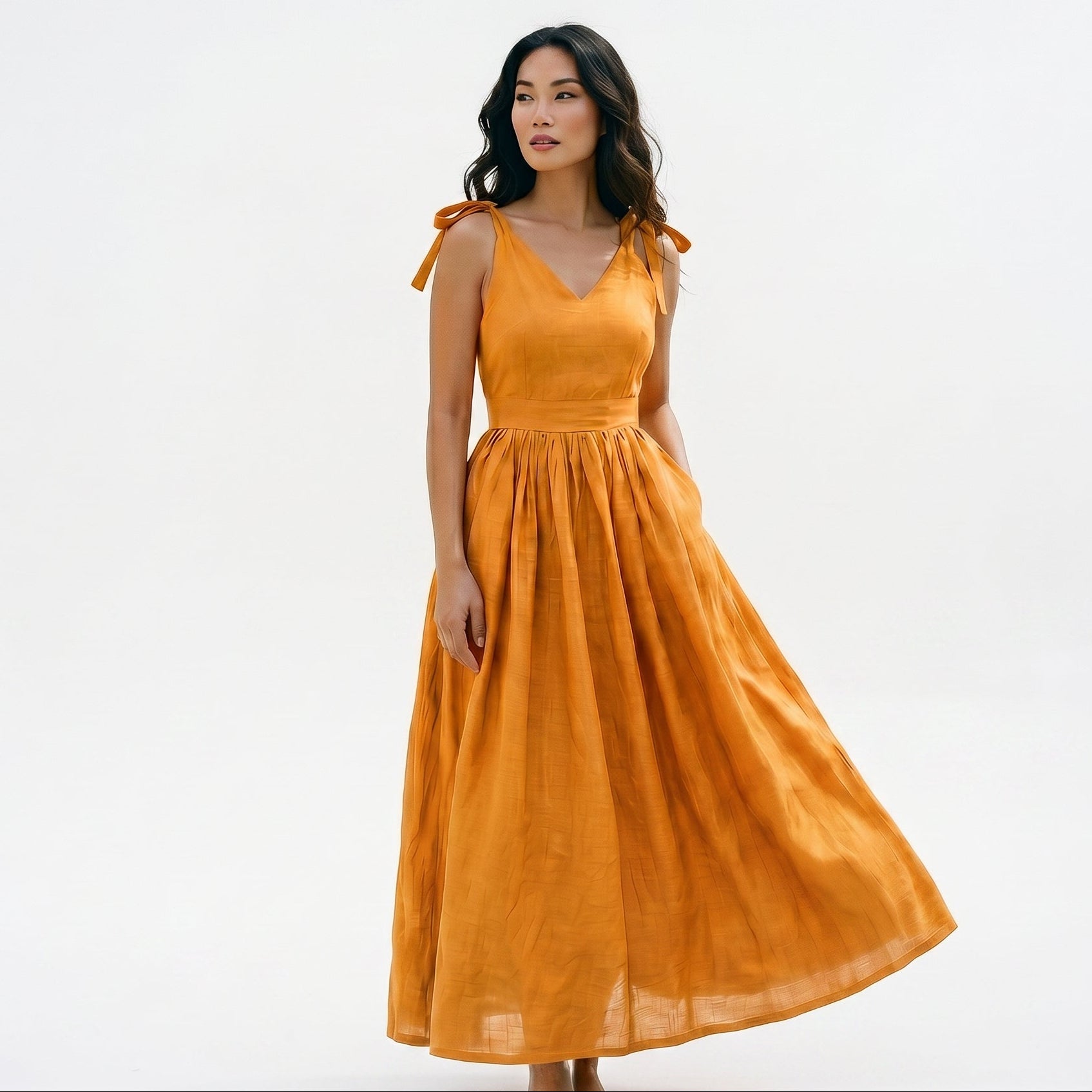 Orange - Model wearing a solid woven maxi dress featuring tie-shoulder straps, a fitted waist, and a full sweeping skirt against a white studio background.