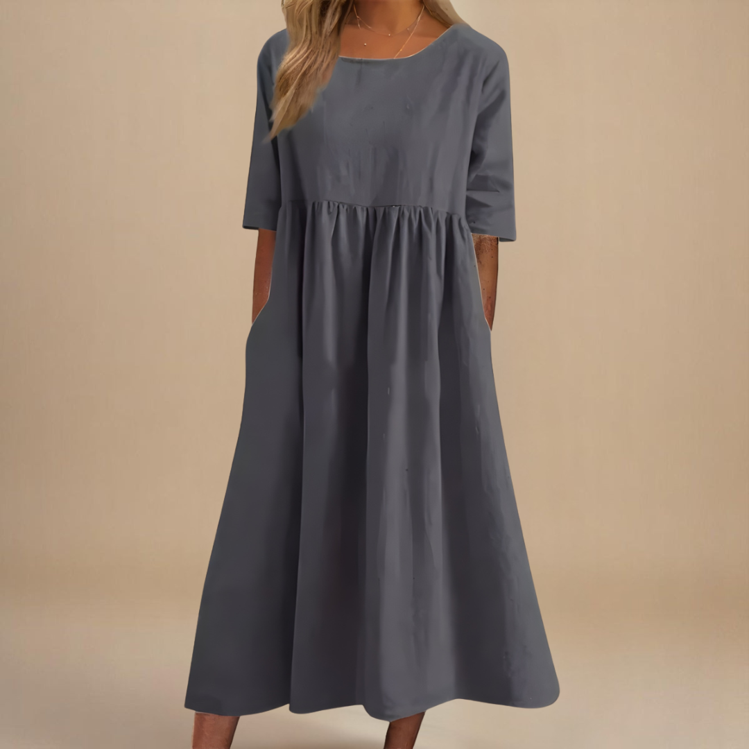 Gray - Woman wearing a solid babydoll midi dress with half sleeves, a gathered high waist, and side pockets.