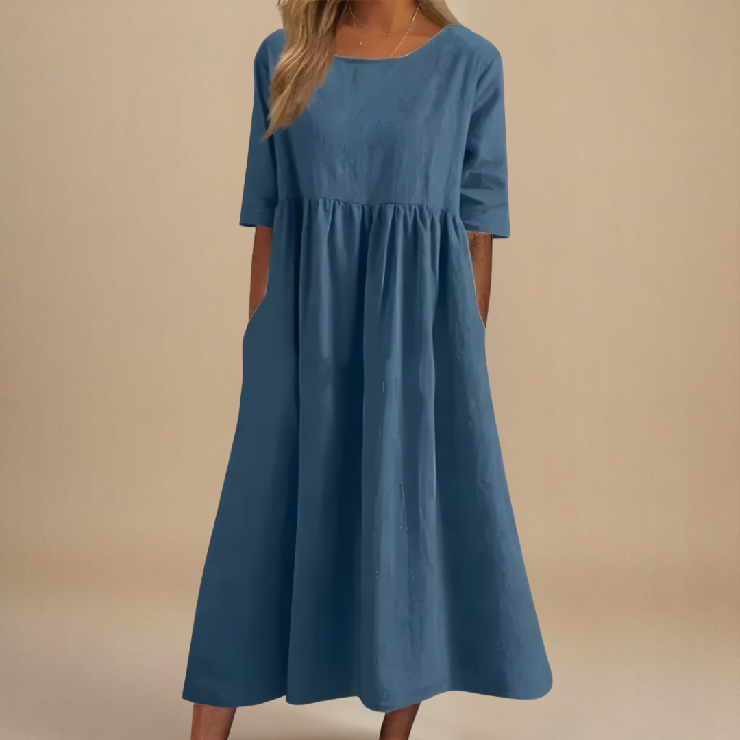 Slate Blue - Woman wearing a solid babydoll midi dress with half sleeves, a gathered high waist, and side pockets.