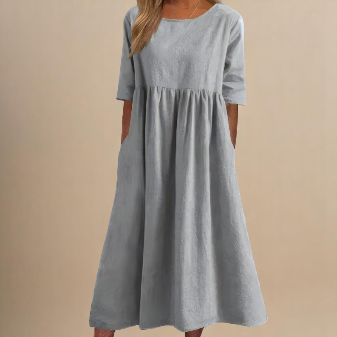 Light Gray - Woman wearing a solid babydoll midi dress with half sleeves, a gathered high waist, and side pockets.