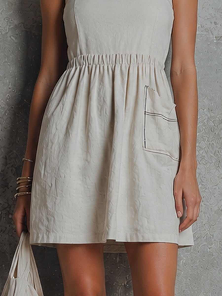Off-White - Woman wearing a woven mini dress with spaghetti straps, a gathered elastic waist, and a front patch pocket with contrast stitching, holding a fabric bag.