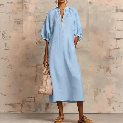 Sky Blue - Woman wearing a loose-fitting linen midi dress with puff sleeves and a zip front neckline
