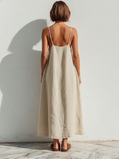Beige - Model wearing an oversized woven maxi dress with spaghetti straps, a V-neckline, and side pockets, standing outdoors in bright sunlight.