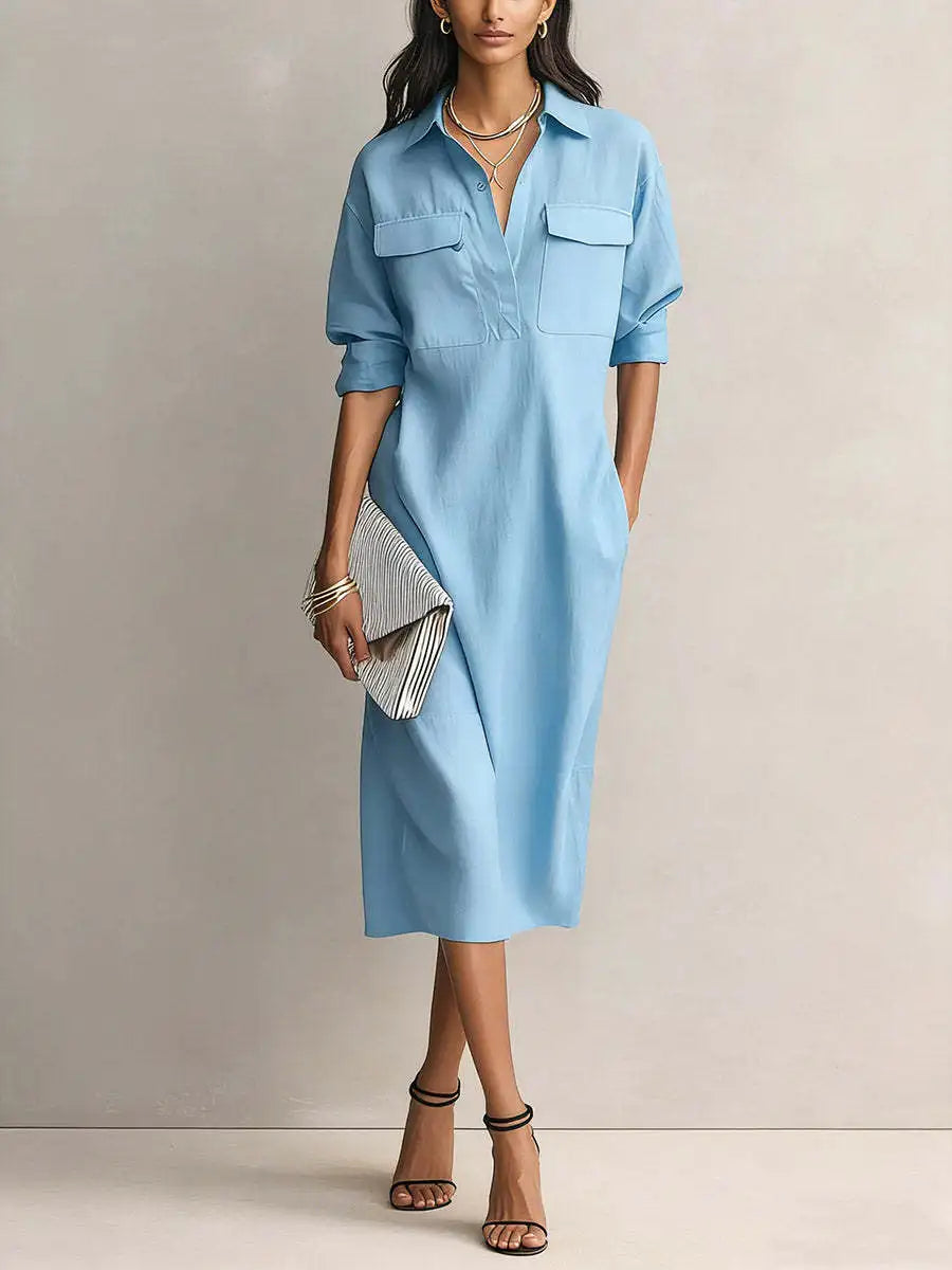 Blue - A woman wearing a light blue linen midi shirt dress with a collar, V-neckline, chest flap pockets, and half sleeves, styled with black strappy heels and a striped clutch.