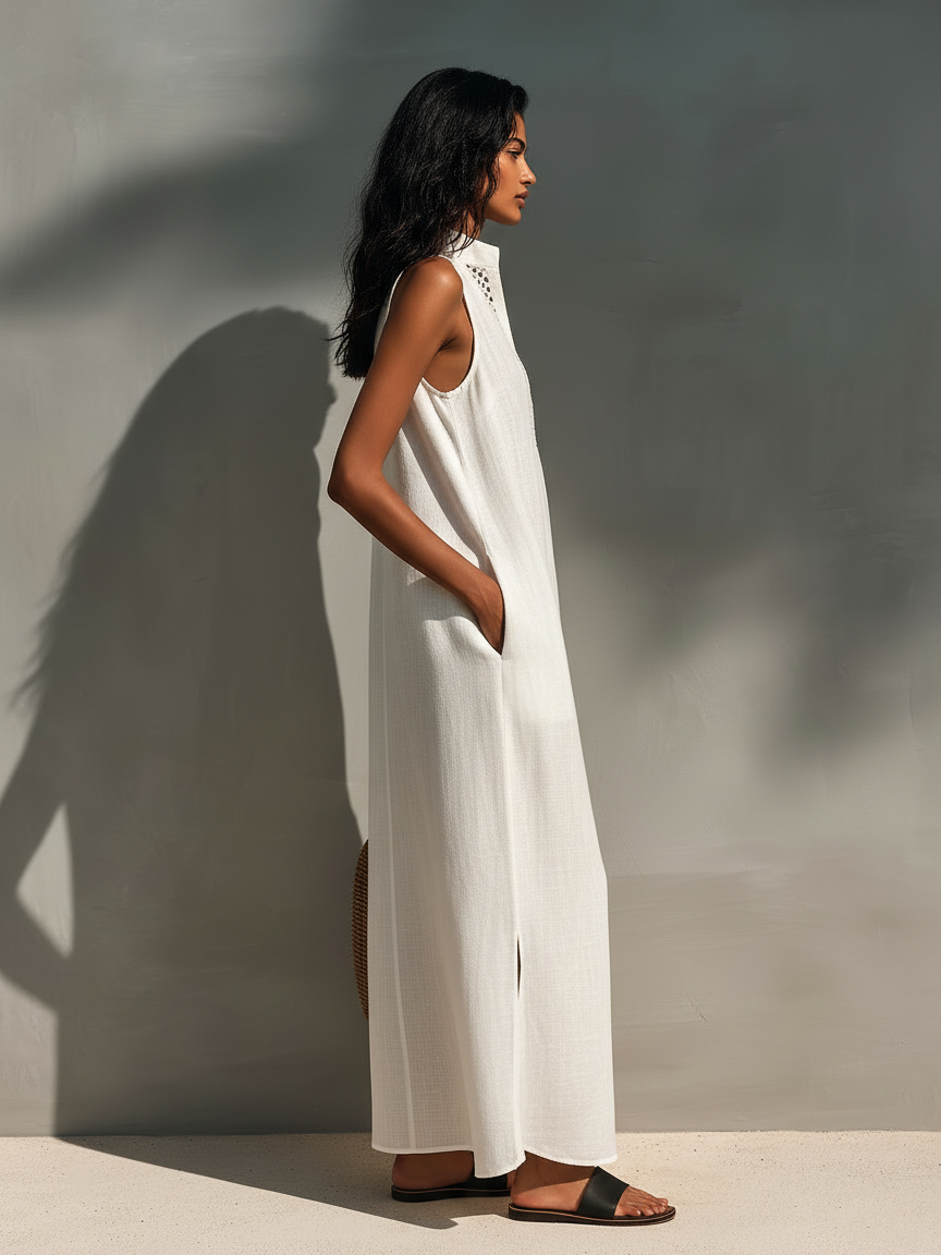 Woman modeling a sleeveless relaxed maxi dress featuring a textured V-neckline and fluid drape, carrying a large woven basket bag.