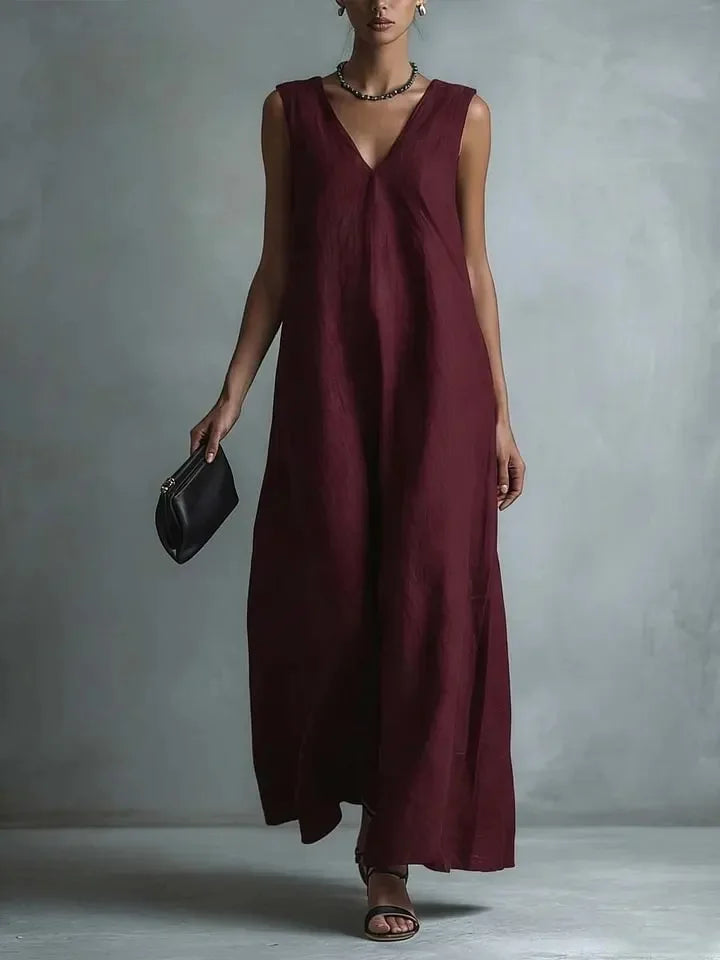 Red - Woman wearing a sleeveless, light-colored linen V-neck maxi dress with a relaxed A-line silhouette, holding a small black clutch.