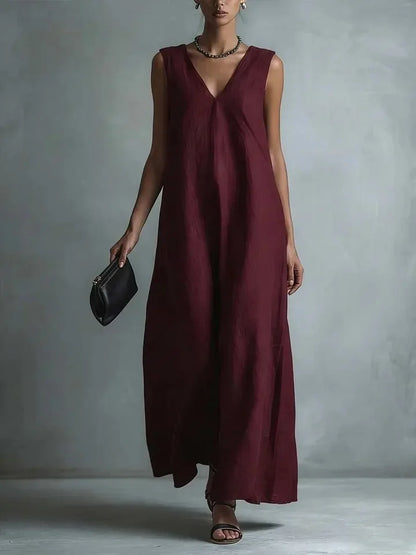 Red - Woman wearing a sleeveless, light-colored linen V-neck maxi dress with a relaxed A-line silhouette, holding a small black clutch.