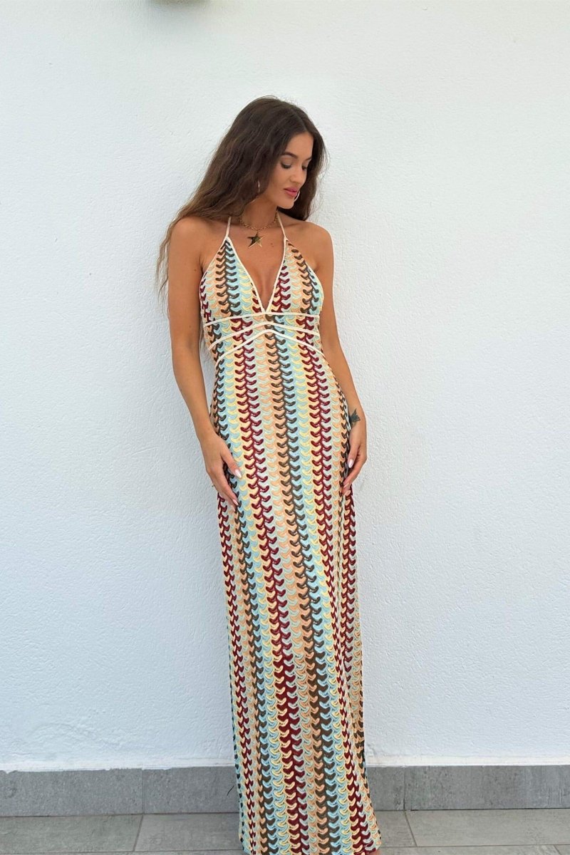 Woman in multi-color crochet knit halter maxi dress