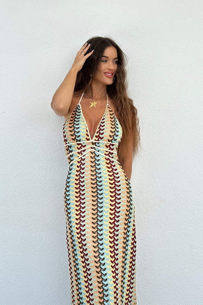 Woman in multi-color crochet knit halter maxi dress