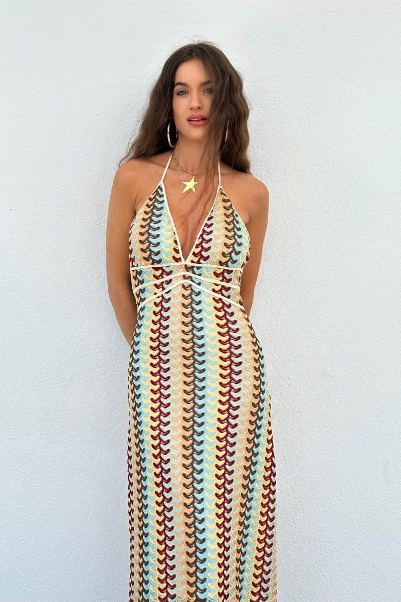Woman in multi-color crochet knit halter maxi dress