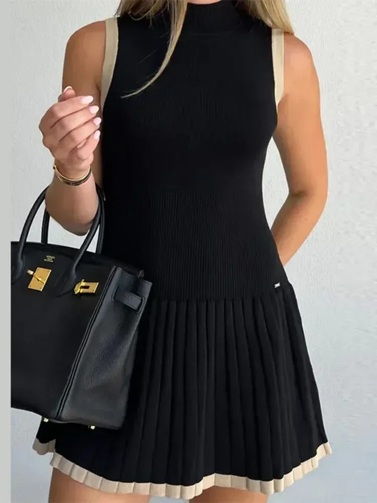 Woman in black ribbed knit mini dress with tan trim, holding coffee and purse.