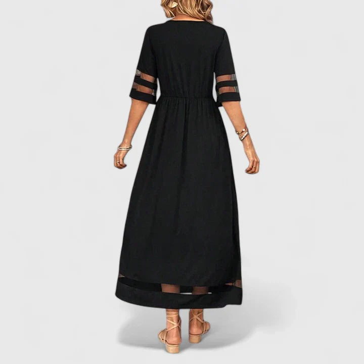 Black - A woman wearing a burgundy maxi dress with elbow-length sleeves and a scoop neckline, featuring sheer mesh stripe inserts on the sleeves and hem, styled with a straw hat and bag.