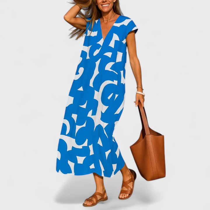 Blue - A woman wearing a black and white abstract graphic print midi dress with a V-neckline, cap sleeves, and a relaxed shift silhouette, styled with brown leather sandals and a shoulder bag.