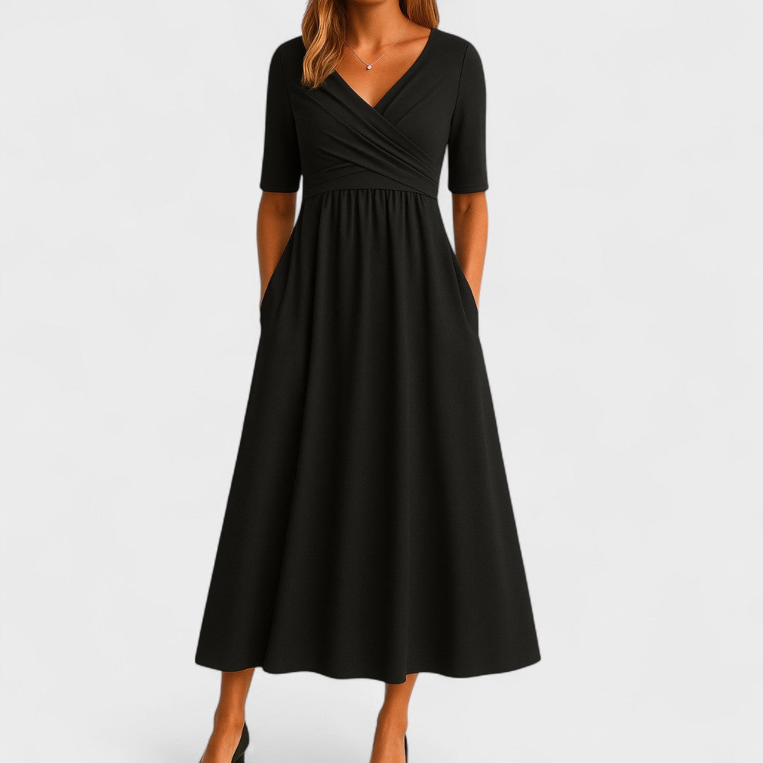 Black (Almost Sold Out) - A woman wearing a heather gray jersey knit midi dress featuring a surplice V-neckline, ruched wrap bodice, short sleeves, and a flowy A-line skirt with side pockets.