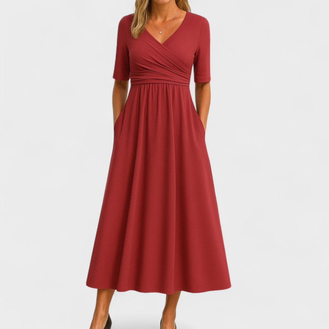 Red - A woman wearing a heather gray jersey knit midi dress featuring a surplice V-neckline, ruched wrap bodice, short sleeves, and a flowy A-line skirt with side pockets.