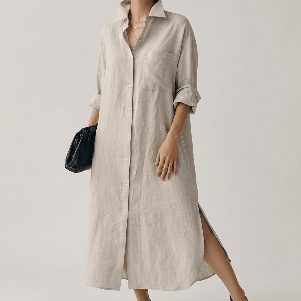 Beige - A woman wearing a black, relaxed-fit linen maxi shirt dress with a collared neckline, button-down front, rolled-up sleeves, and high side slits, paired with a dark blue clutch bag.