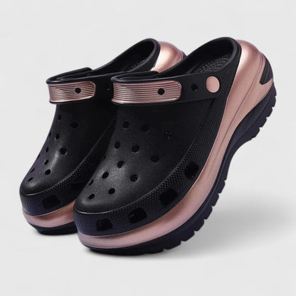 Black - Molded foam slip-on platform clogs featuring ventilation ports across the upper, a pivoting heel strap, and a distinct metallic trim along the thick midsole