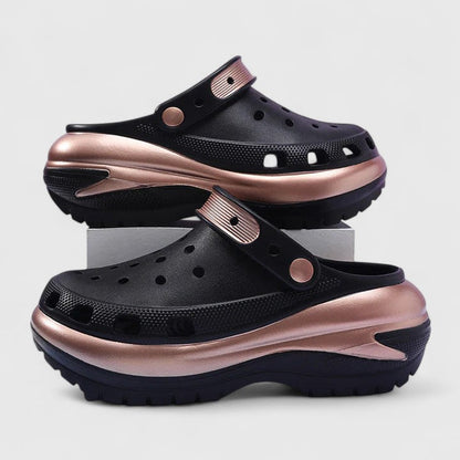 Black - Molded foam slip-on platform clogs featuring ventilation ports across the upper, a pivoting heel strap, and a distinct metallic trim along the thick midsole