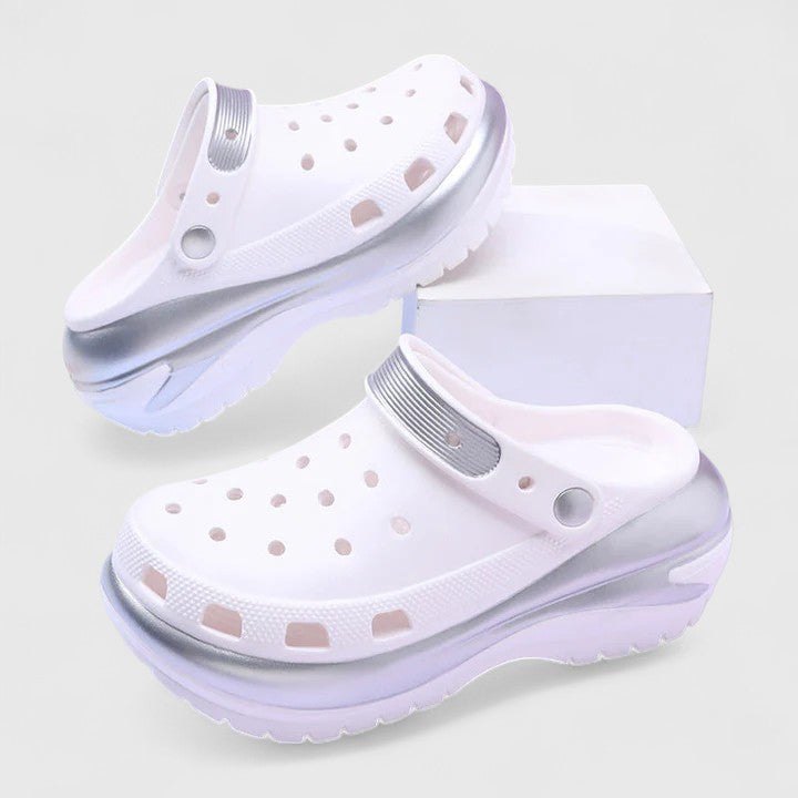 Black - Molded foam slip-on platform clogs featuring ventilation ports across the upper, a pivoting heel strap, and a distinct metallic trim along the thick midsole