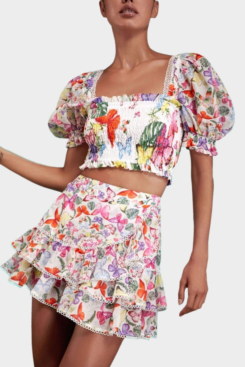 Woman wearing butterfly print crop top and ruffle skirt set