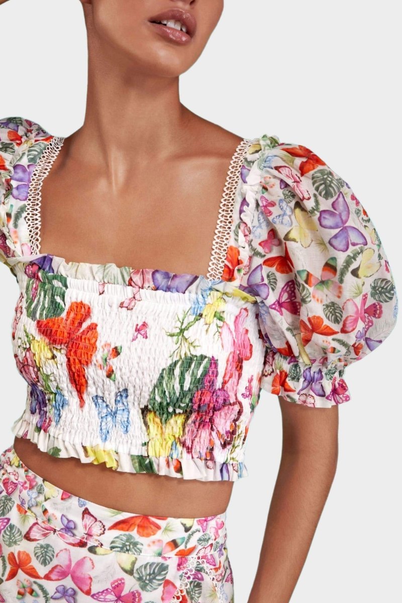 Woman wearing butterfly print crop top and ruffle skirt set