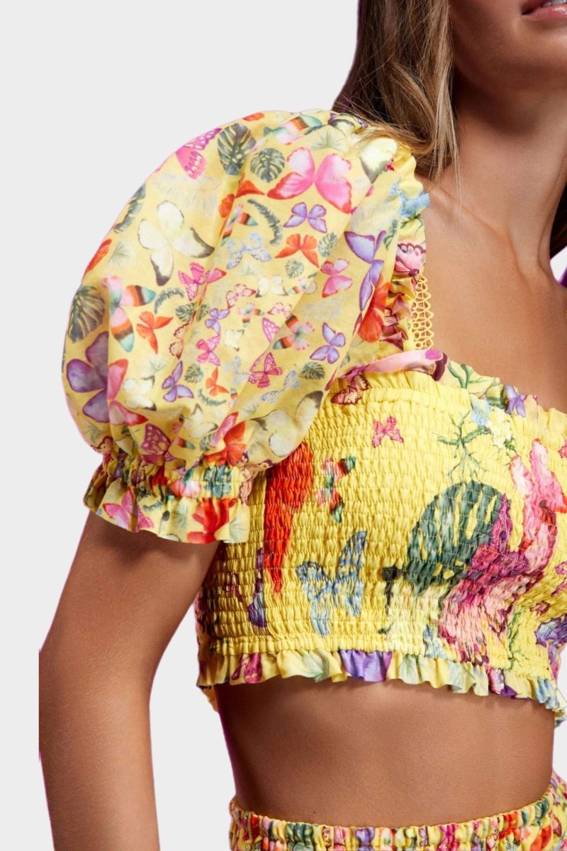 Woman wearing butterfly print crop top and ruffle skirt set