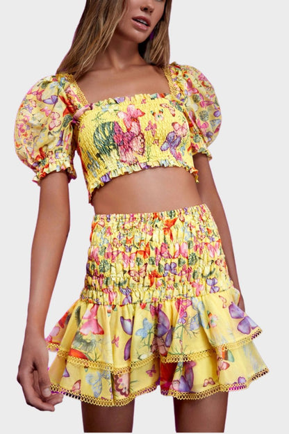 Woman wearing butterfly print crop top and ruffle skirt set