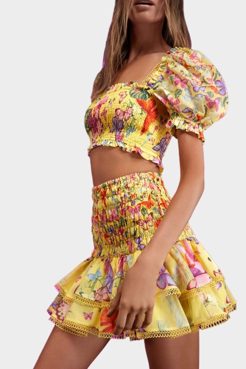 Woman wearing butterfly print crop top and ruffle skirt set