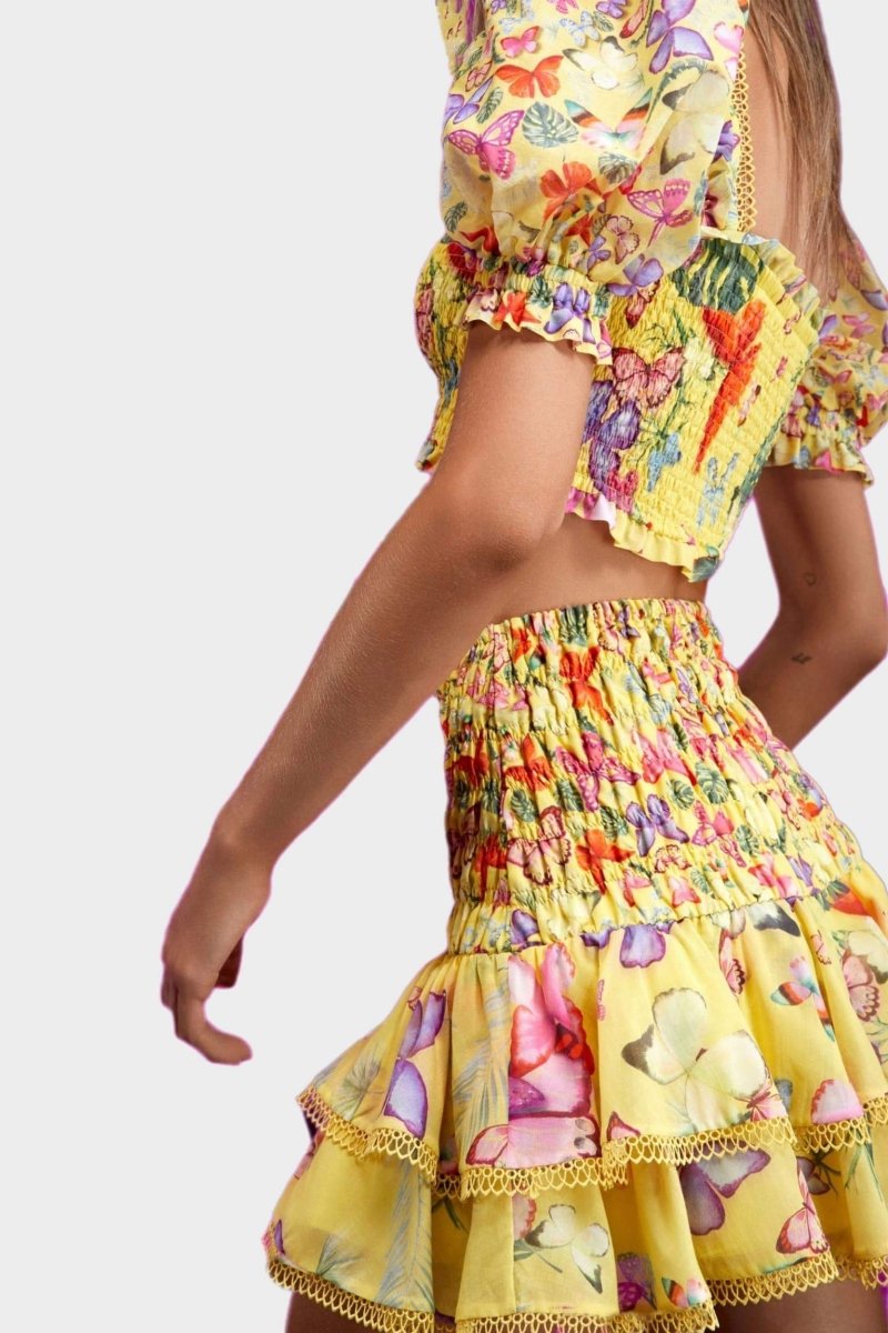 Woman wearing butterfly print crop top and ruffle skirt set