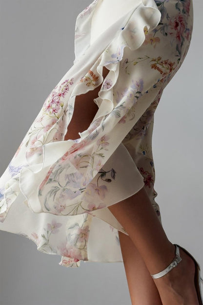 A woman wearing a floral chiffon dress with ruffles.