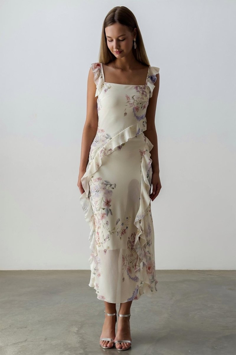 A woman wearing a floral chiffon dress with ruffles.