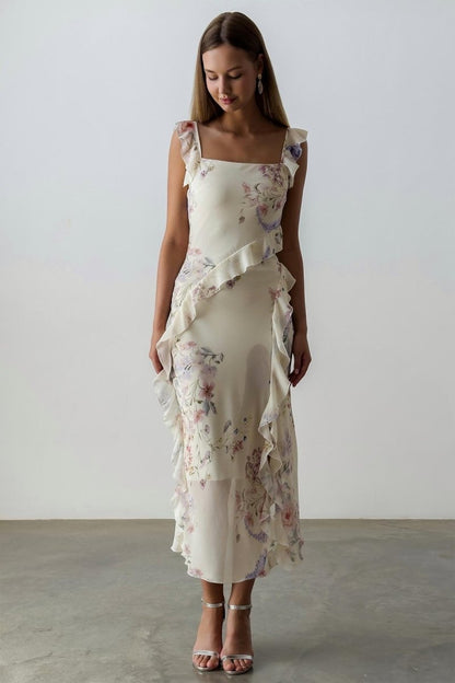 A woman wearing a floral chiffon dress with ruffles.