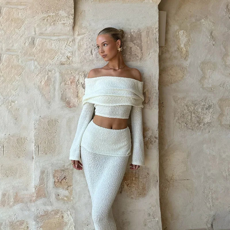 Woman in white boucle off-the-shoulder crop top and midi skirt set.
