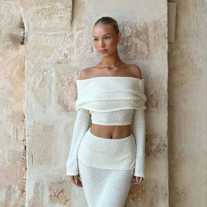 Woman in white boucle off-the-shoulder crop top and midi skirt set.