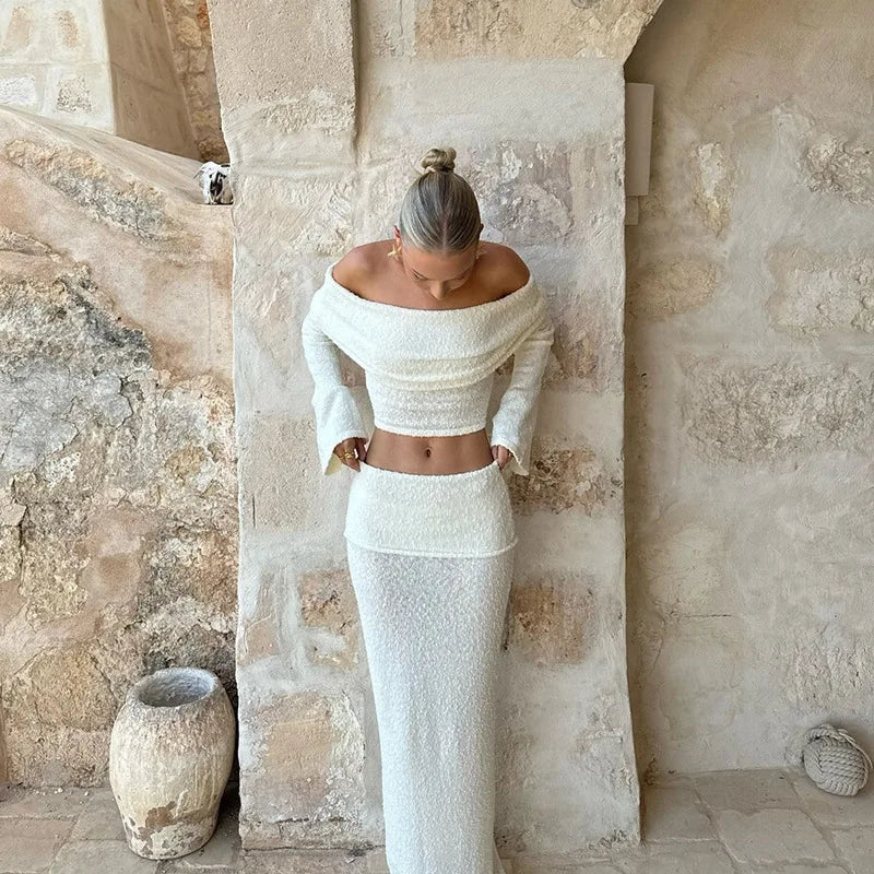Woman in white boucle off-the-shoulder crop top and midi skirt set.