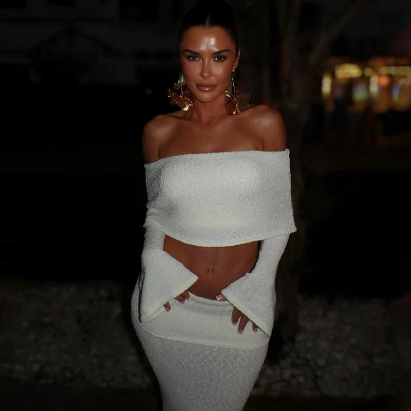Woman in white boucle off-the-shoulder crop top and midi skirt set.