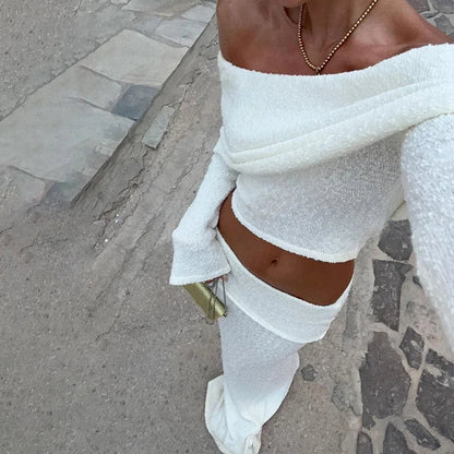 Woman in white boucle off-the-shoulder crop top and midi skirt set.