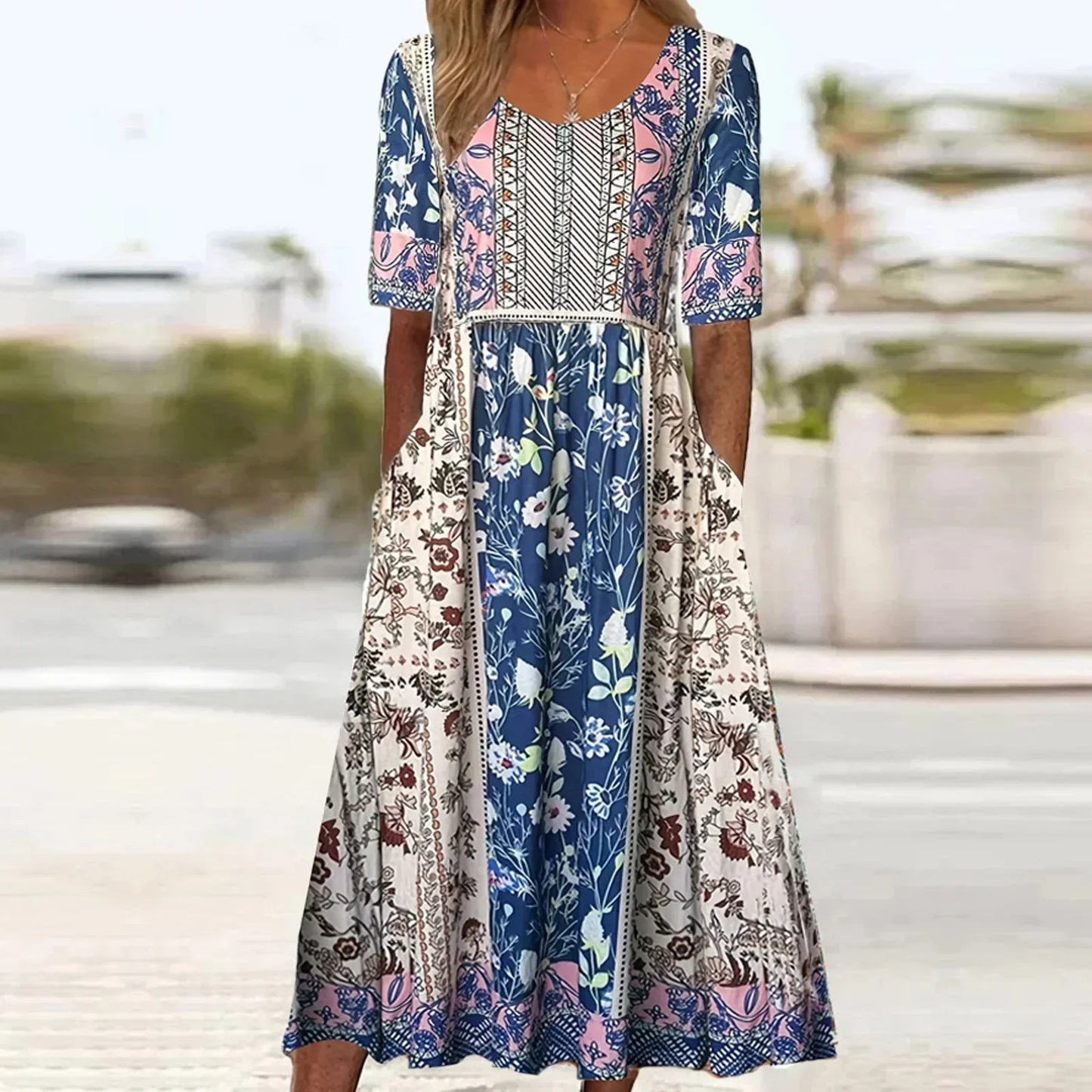 Multicolor2 - A woman wearing a bohemian-style maxi sundress featuring a multi-colored paisley and ditsy floral print, scoop neckline, half sleeves, and functional side pockets.