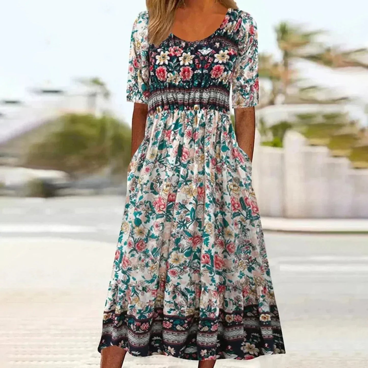 Multicolor5 - A woman wearing a bohemian-style maxi sundress featuring a multi-colored paisley and ditsy floral print, scoop neckline, half sleeves, and functional side pockets.
