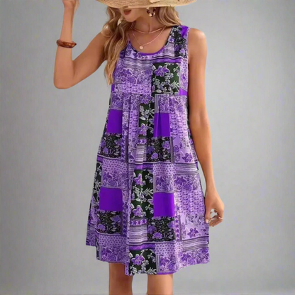 Purple - A woman wearing a sleeveless mini dress featuring a multi-colored patchwork floral print in orange, navy, and cream, styled with a scoop neckline and a gathered empire waist.