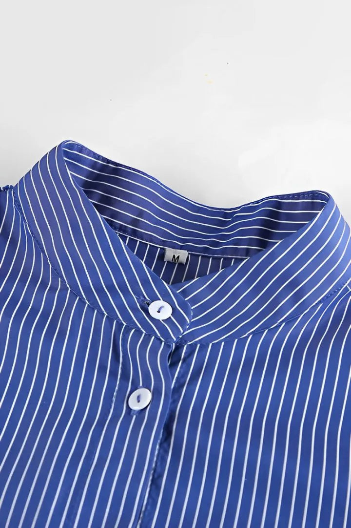 Woman wearing oversized blue and white striped shirt with black pants and sunglasses