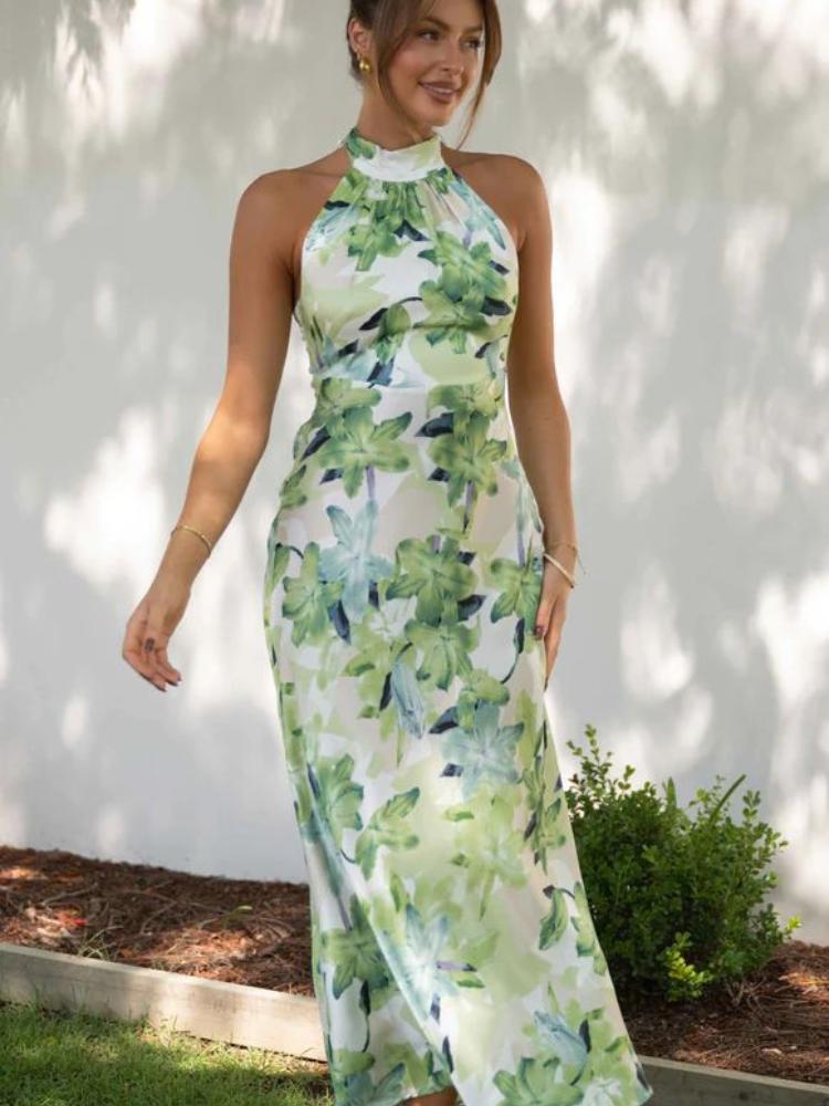 Woman in green floral satin halter maxi dress