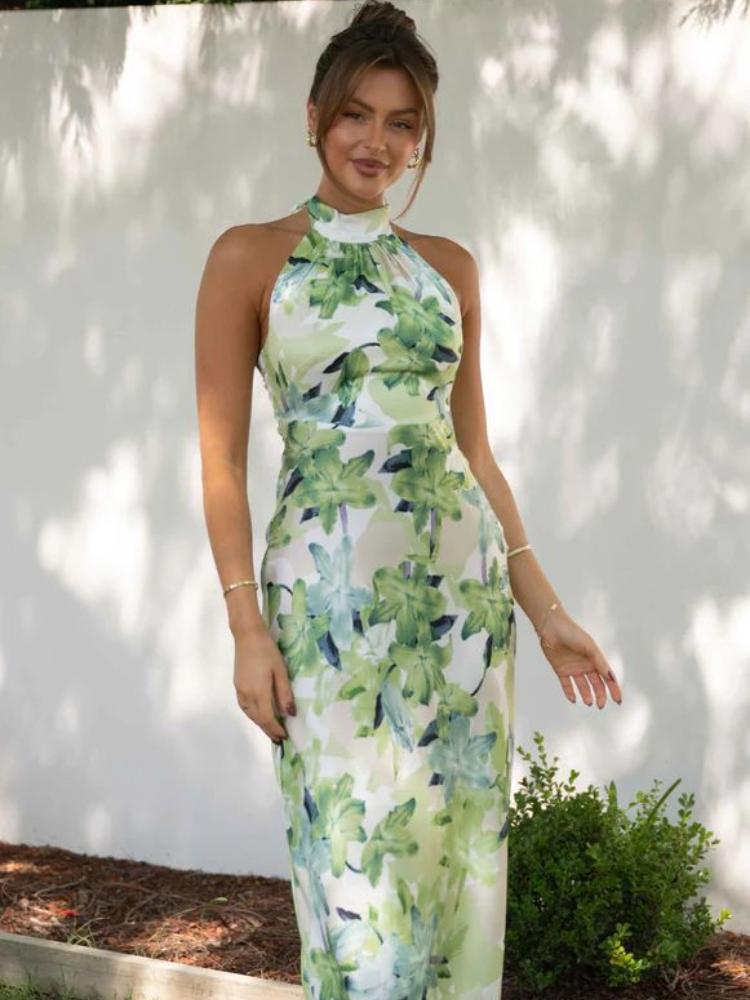 Woman in green floral satin halter maxi dress