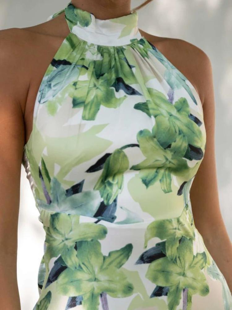 Woman in green floral satin halter maxi dress